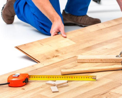 carpenter worker installing laminate flooring in the room